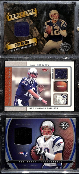 (3) 2003 Tom Brady Jersey Relic Cards (Hogg Heaven Game-Used Jersey #/75; Fleer Genuine Game-Used Jersey #/199; & an Upper Deck Standing O Event-Worn Jersey) 