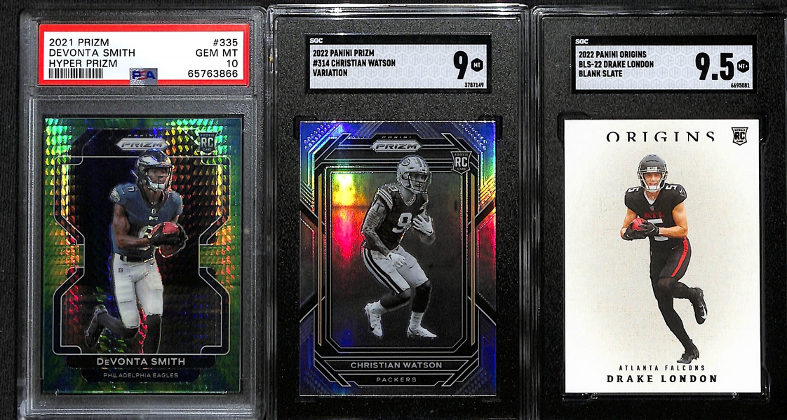 Lot of (3) Young Superstar Wide Receiver Graded Rookie Cards Inc. 2021 Prizm Devonta Smith Hyper (PSA 10) (#/175), 2022 Prizm Christian Watson Variation (SGC 9), 2022 Origins Drake London Blank...